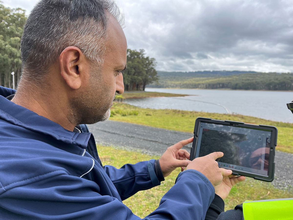 Ram Ramzan reviews drone footage on a tablet at Silvan Dam