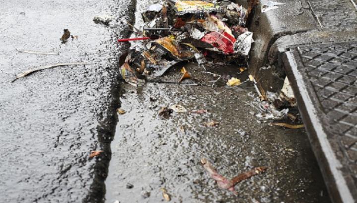 Rubbish collected in a street gutter near a stormwater drain