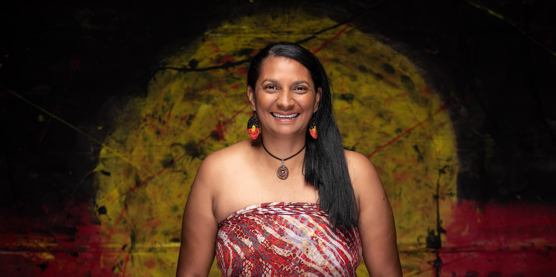 Nova Peris in front of an Aboriginal flag