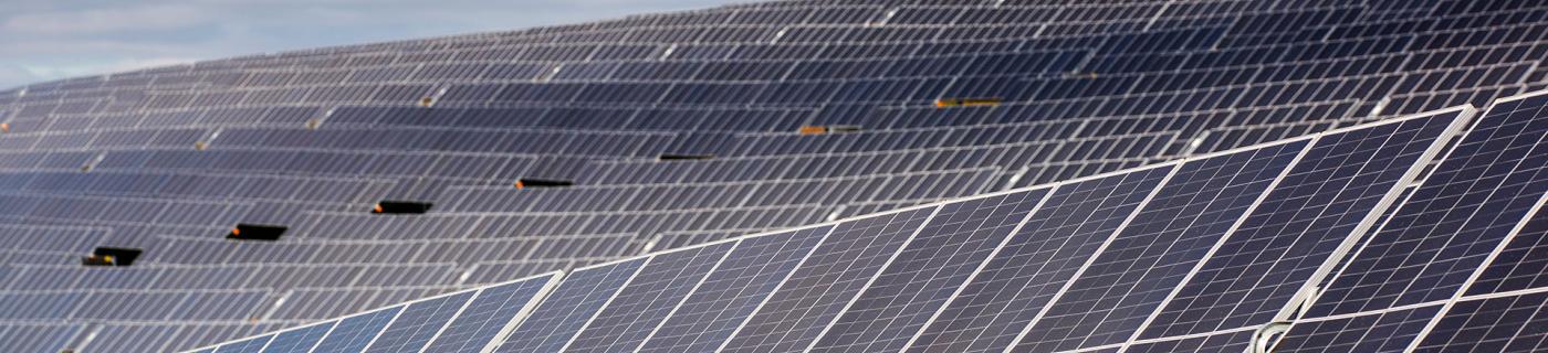 Rows of solar panels on a hill at Winneke Water Treatment Plant, partly shadowed by clouds