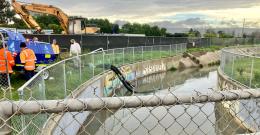 Melbourne Water staff pump water contaminated water from a creek