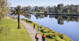 Cyclists riding along the Maribyrnong River on a clear day