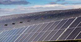 Rows of solar panels on a hill at Winneke Water Treatment Plant, partly shadowed by clouds