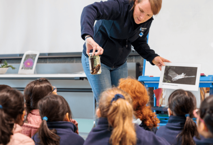 Educator showing school children a preserved bat specimen