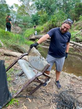 Volunteer pulls chair from the creek.