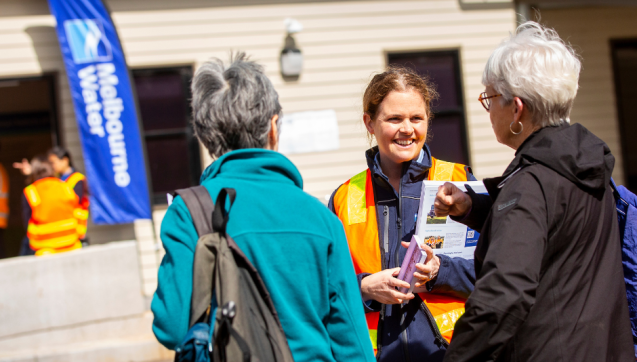 Melbourne Water guide talking to two older women outside a tour facility