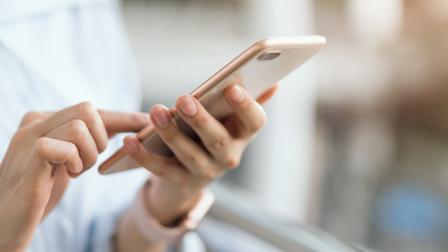 Person holding mobile phone and using touch screen to make a call